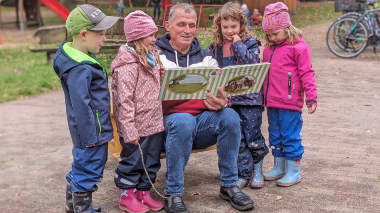 Bokels Bürgermeister Ralf Horstmann liest Kindern aus einem plattdeutschen Buch vor