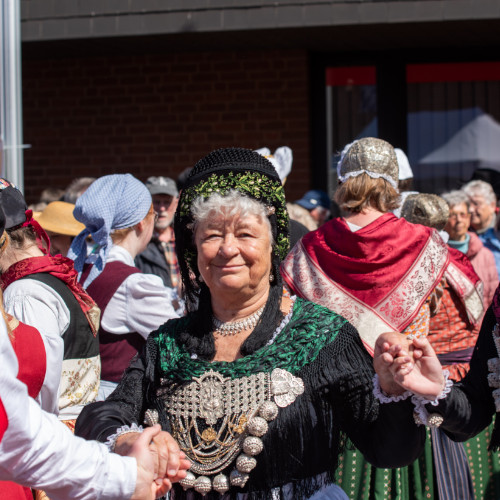 Frau in Tracht, dahinter weitere Personen in Tracht