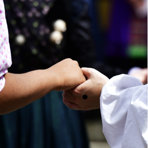 Zwei Trachtenträgerinnen halten sich an den Händen