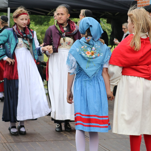 Vier Kinder oder Jugendliche in Tracht beim Tanzen