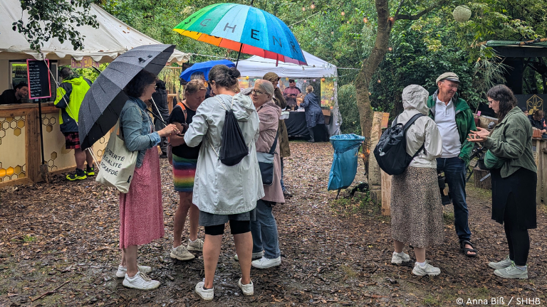 Menschen mit Regenschirmen stehen zusammen