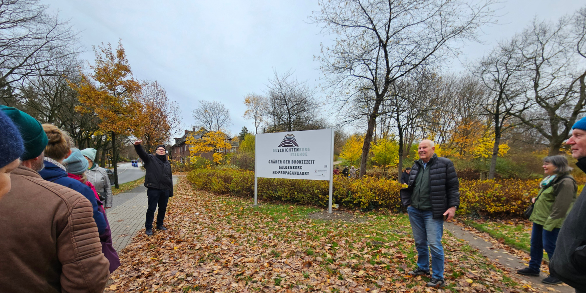 Menschen vor Schild Geschichtenberg Itzehoe