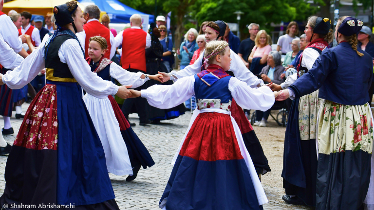 Junge und alte Trachtentänzerinnen im Tanzkreis