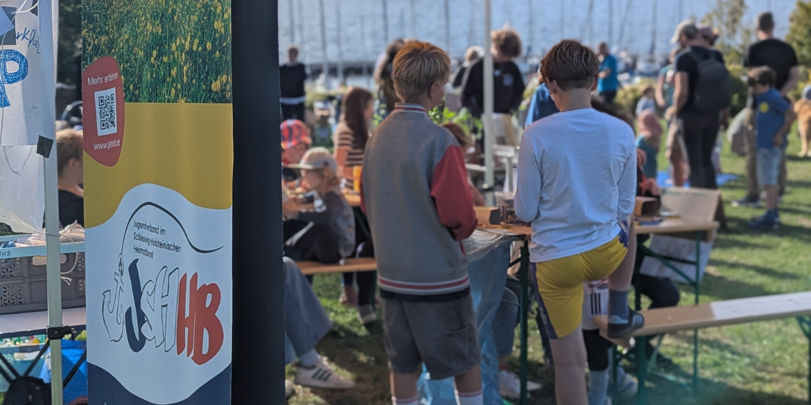 Banner JSHHB im Hintergund Kinder am Stand