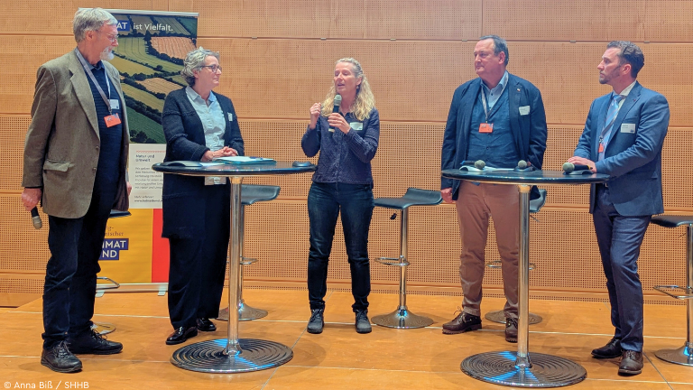 Fünf Personen auf Podium