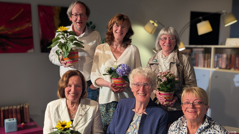 sechs Personen mit Blumen