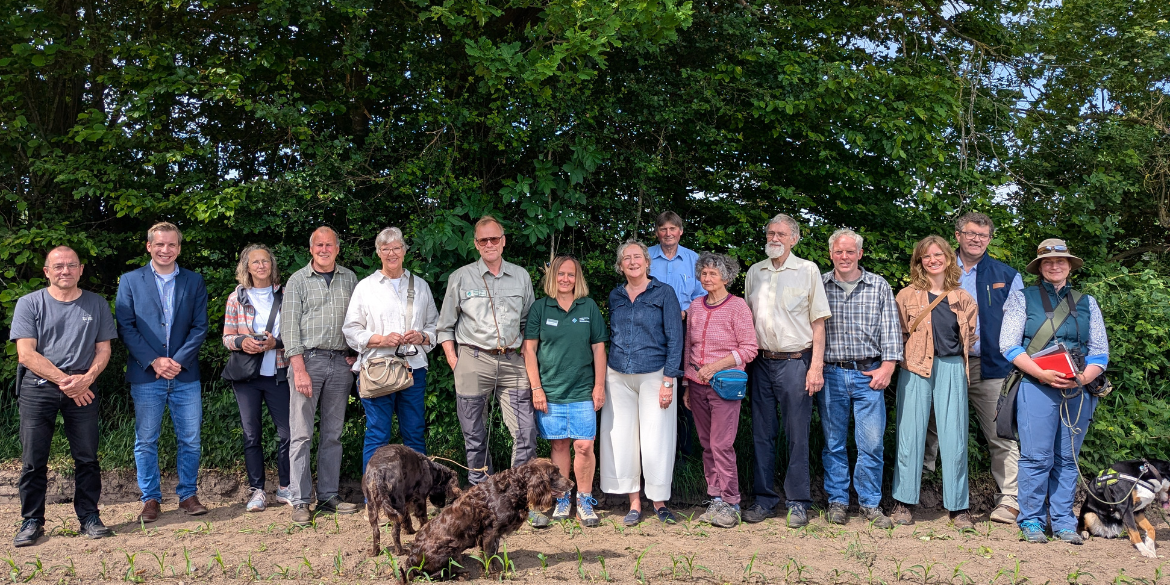 Gruppenbild vor einem grünen Knick