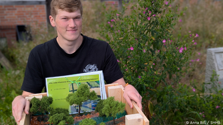 Junger Mann mit Kiste auf dem Schoss
