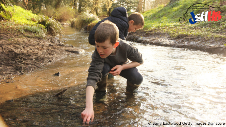 Zwei Jungs spielen in einem Bach