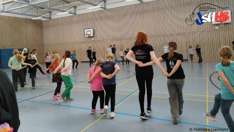 Jugendliche tanzen in einer Turnhalle