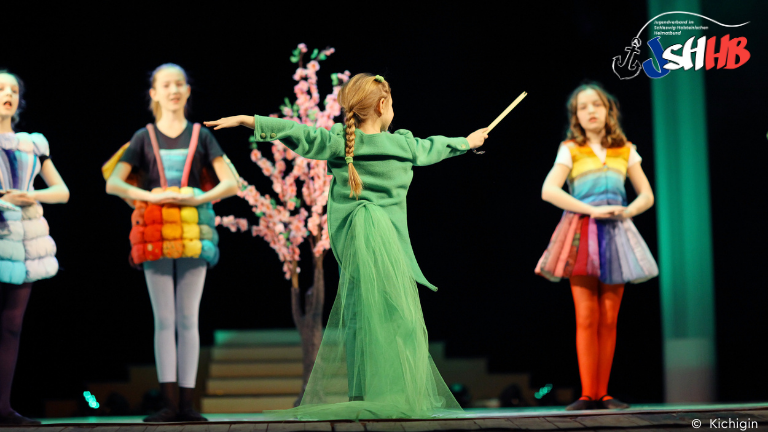 Mädchen spielen verkleidet Theater auf einer Bühne